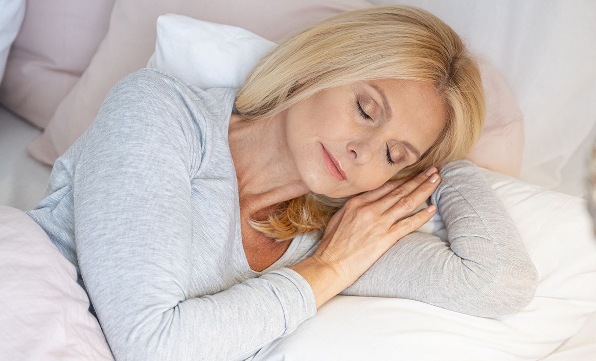 Frau mit geschlossenen Augen auf Bett