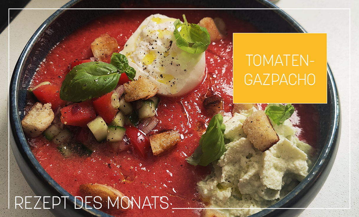 Tomatengazpacho mit Basilikumespuma & Burrata in dunkelblauer Schüssel
