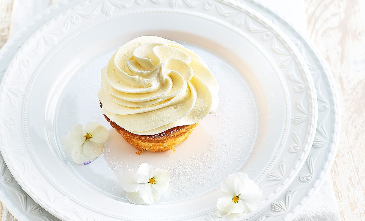 Zitronencupcake mit Buttercreme auf weißem Teller